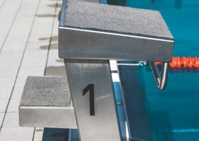 a row of benches sitting next to a swimming pool